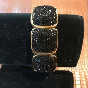 Jet Black sparkles stone with gold-tone frame.